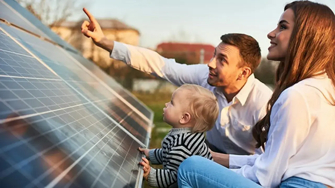 Rodzina przy panelach fotowoltaicznych. Tata pokazuje synkowi, jak zrobić panel fotowoltaiczny, wyjaśniając działanie energii słonecznej.