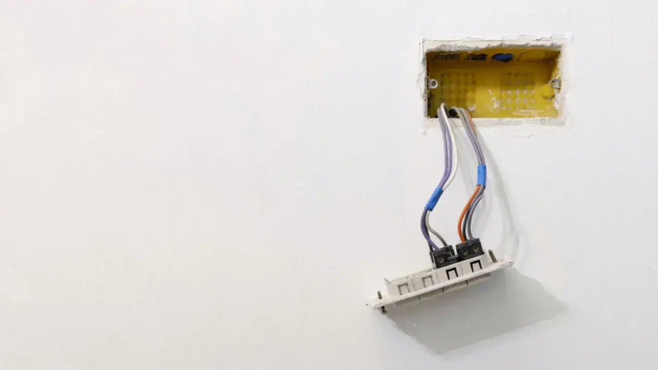 Instalacja elektryczna: przewody wychodzące z żółtej puszki, gotowe do montażu gniazdka. Dowiedz się, jak osadzić puszki elektryczne.