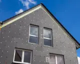 Izolacja domu z grafitowego styropianu, z widocznymi oknami i dachem. Czy styropian się pali? To pytanie nurtuje wielu, ale nowoczesne materiały są bezpieczne.