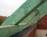 Zielona murłata, czyli belka oporowa dachu, mocowana do ceglanej ściany. To kluczowy element konstrukcji dachu.
