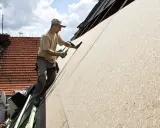Czym pokryć dach z płyty OSB? Dachnik montuje płyty OSB, przygotowując podłoże pod pokrycie dachowe.