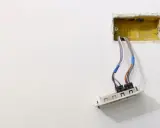 Instalacja elektryczna: przewody wychodzące z żółtej puszki, gotowe do montażu gniazdka. Dowiedz się, jak osadzić puszki elektryczne.