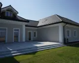 Elegancki dom z tarasem i schodami. Widoczny ozdobny gzyms co to za element architektoniczny, dodający klasy.