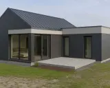 Nowoczesny dom z rozbudową, z ciemnoszarą elewacją i dużymi przeszkleniami.