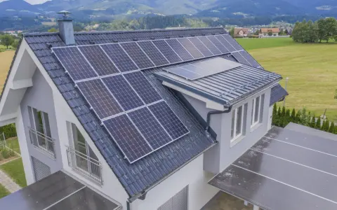 Dom z panelami fotowoltaicznymi na dachu. Energia słoneczna wady i zalety są widoczne w tej ekologicznej inwestycji.