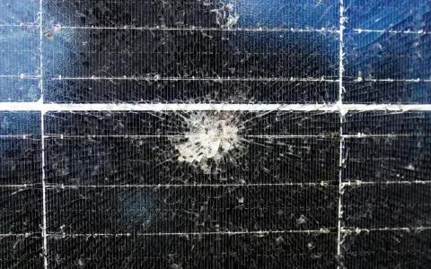 Uszkodzony panel fotowoltaiczny z pękniętym szkłem. Taki defekt znacząco obniża wydajność paneli fotowoltaicznych.