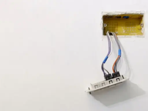 Instalacja elektryczna: przewody wychodzące z żółtej puszki, gotowe do montażu gniazdka. Dowiedz się, jak osadzić puszki elektryczne.