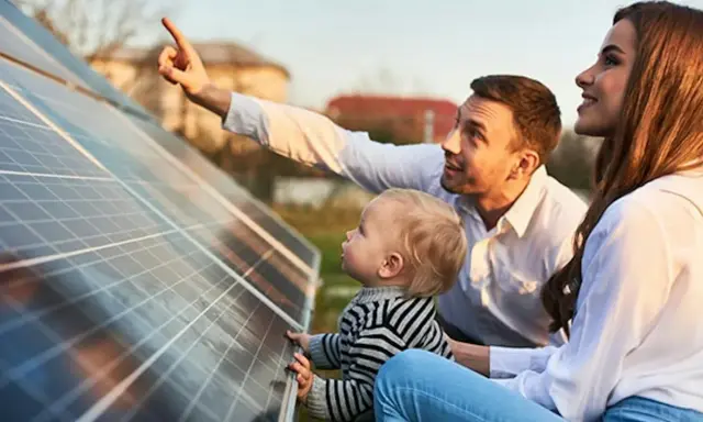 Rodzina przy panelach fotowoltaicznych. Tata pokazuje synkowi, jak zrobić panel fotowoltaiczny, wyjaśniając działanie energii słonecznej.