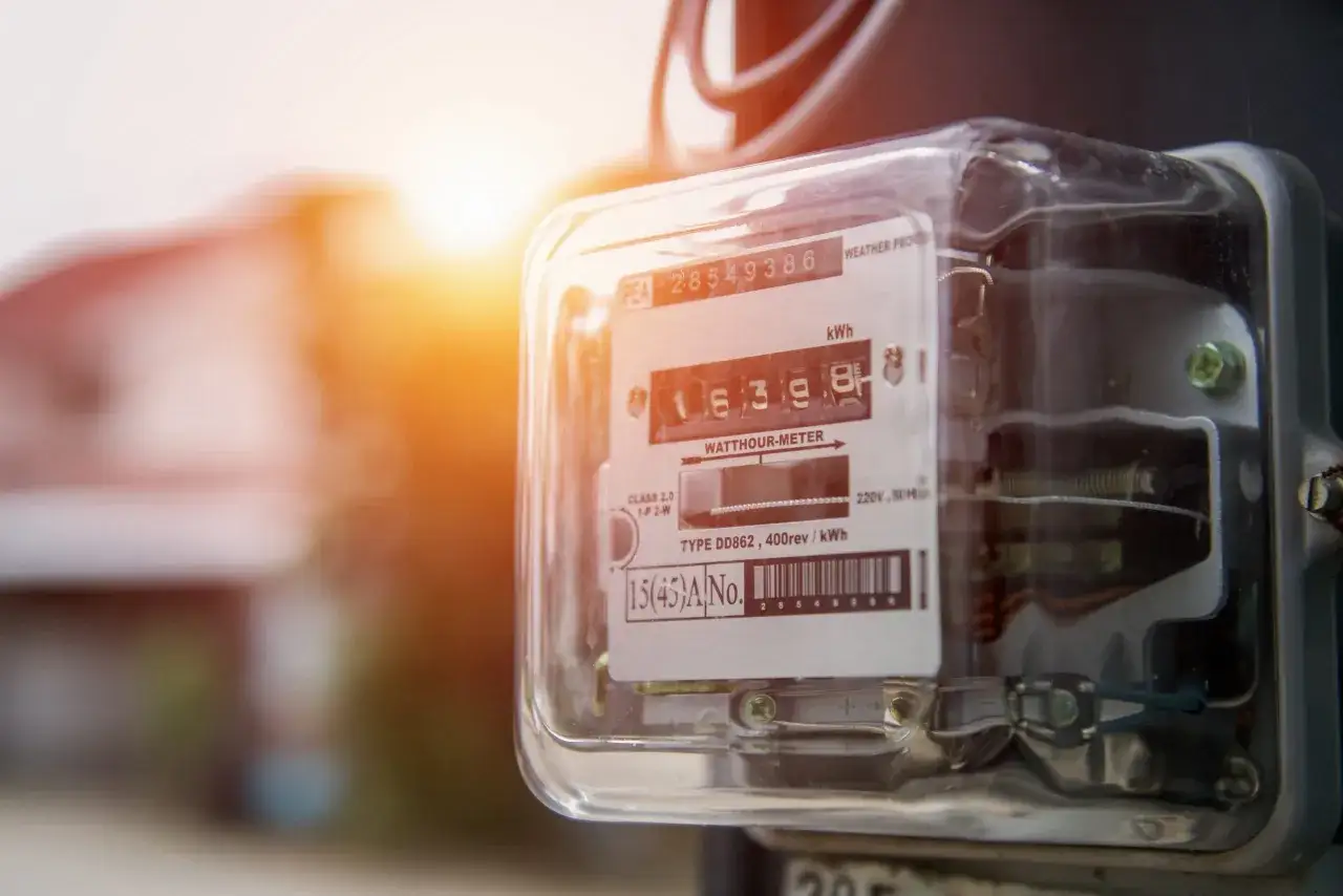 Widok z bliska na licznik energii elektrycznej, jeden z rodzajów liczników, z widocznymi cyframi i oznaczeniami.